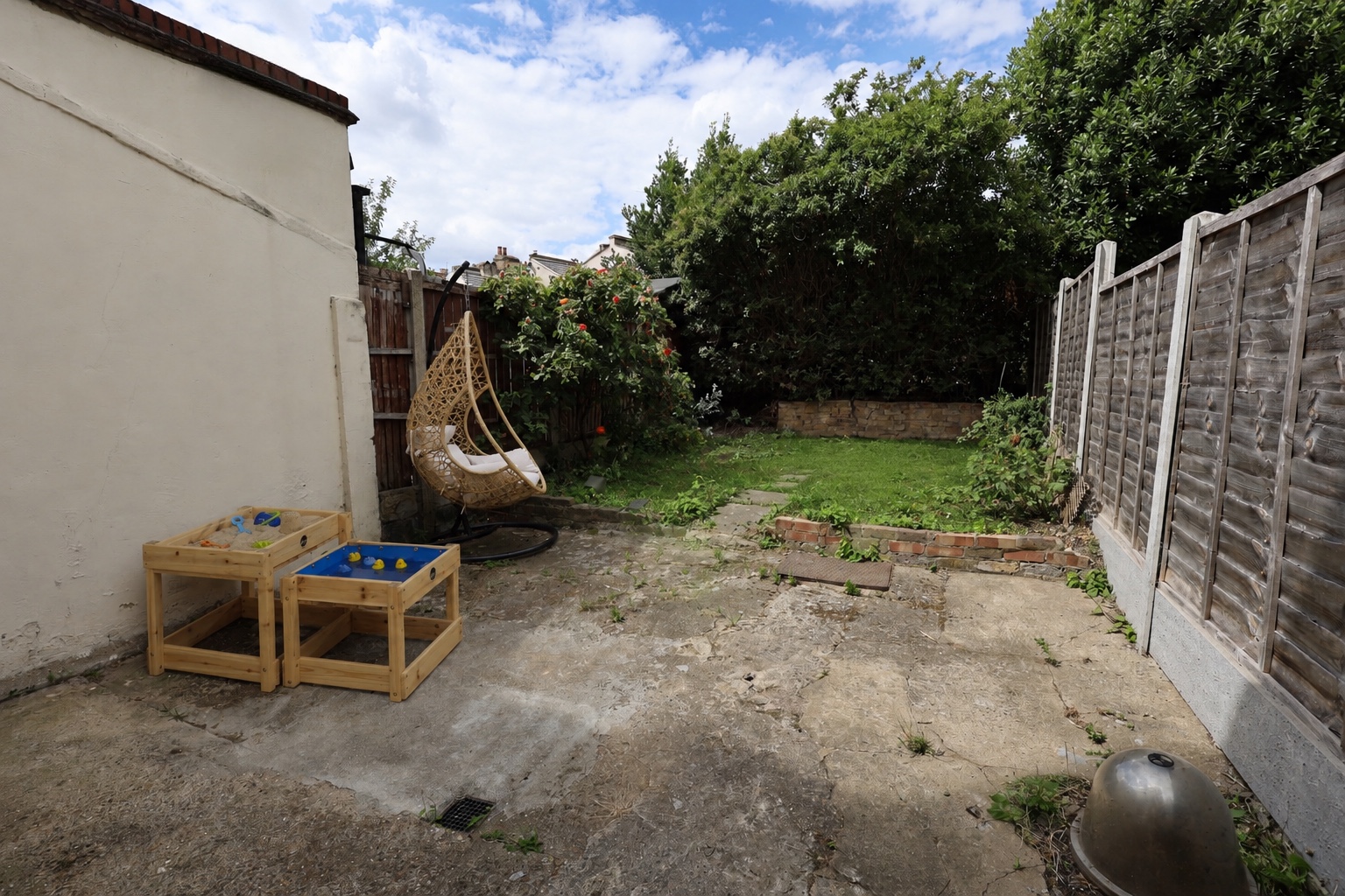 The Root and Bloom garden with outdoor play tables and a hanging chair